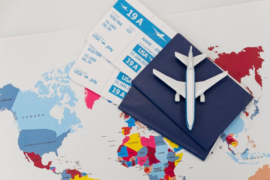 Pasaportes, boletos de avión y un avión de juguete sobre un mapa, simbolizando la subrogación en México para extranjeros.