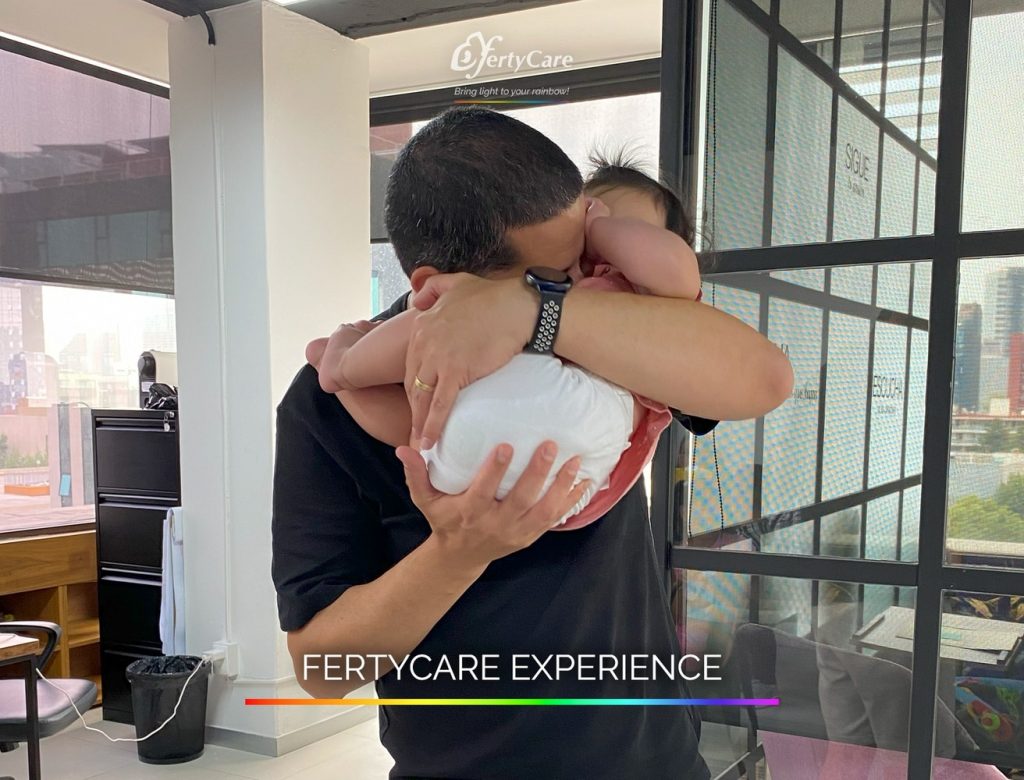 Hombre sosteniendo a su bebé en brazos dentro de las oficinas de FertyCare, representando la experiencia de subrogación.