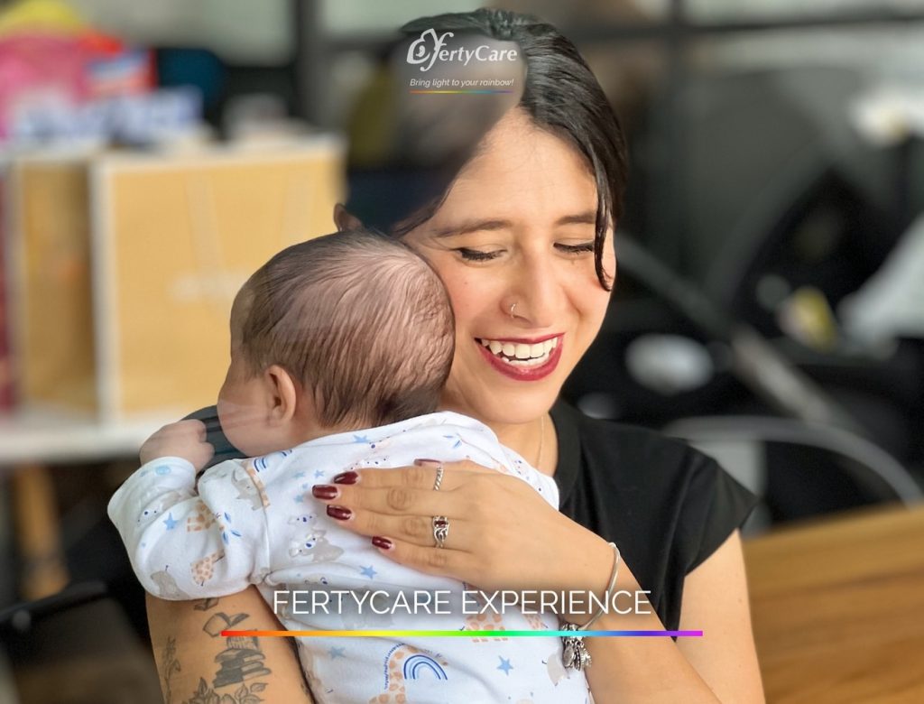 Mujer sonriendo mientras sostiene a su bebé en brazos, representando la experiencia de subrogación en FertyCare.